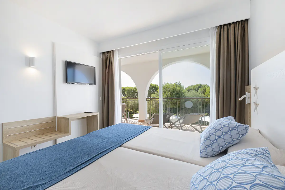 Dormitorio equipado con televisión y salida a la terraza en Hotel Cala d’Or Playa