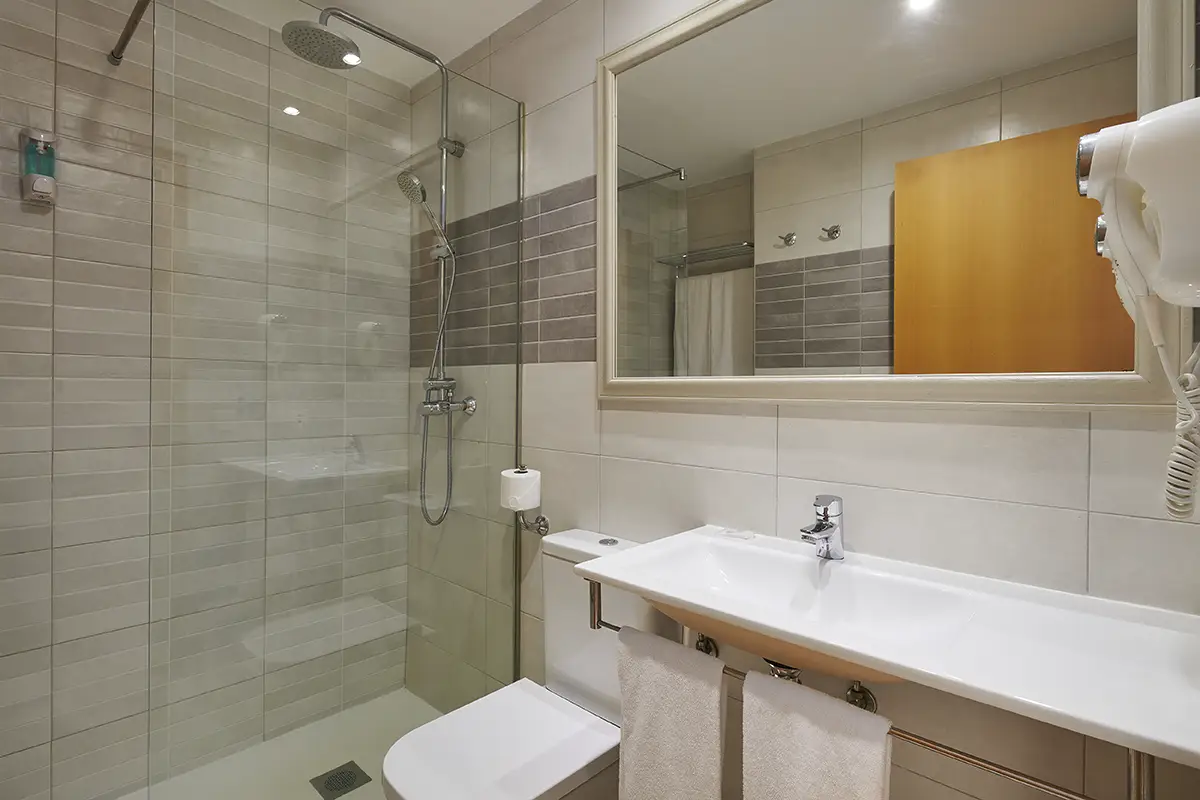 Baño moderno y funcional con ducha en Hotel Cala d’Or Playa