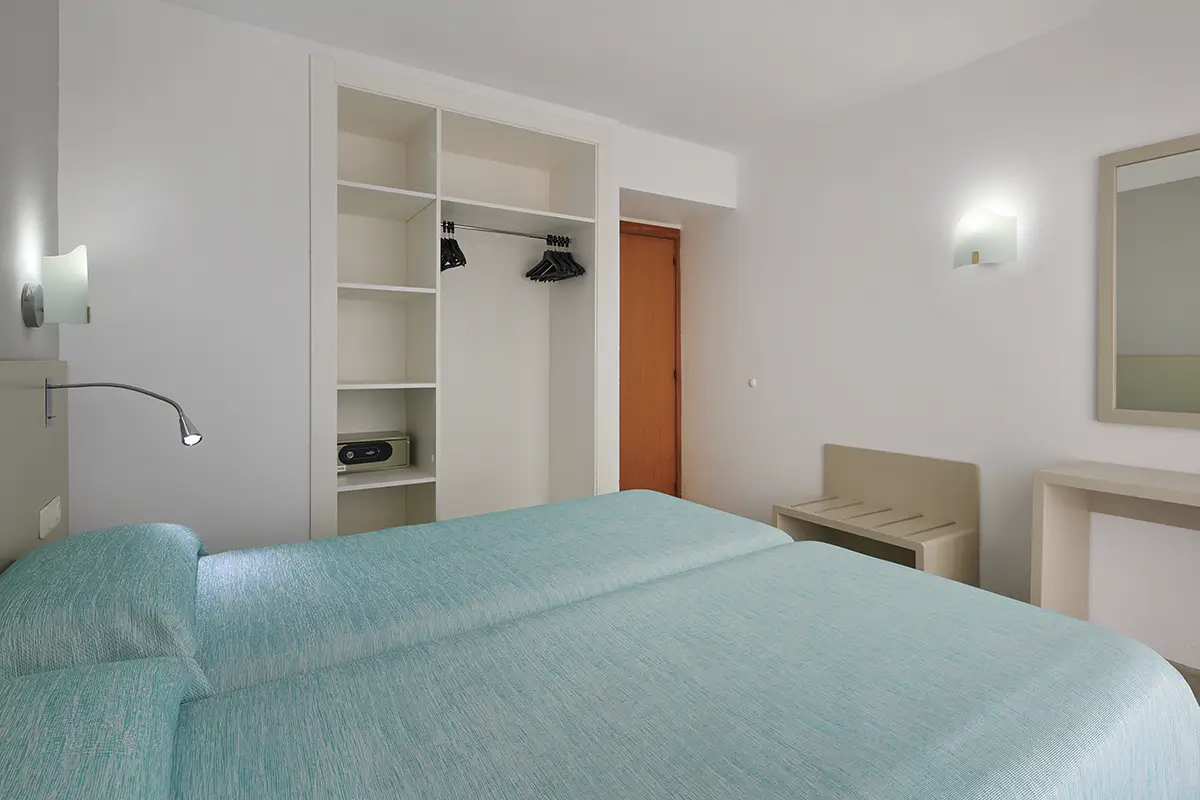 Dormitorio con camas twin y armario empotrado en Hotel Cala d’Or Playa