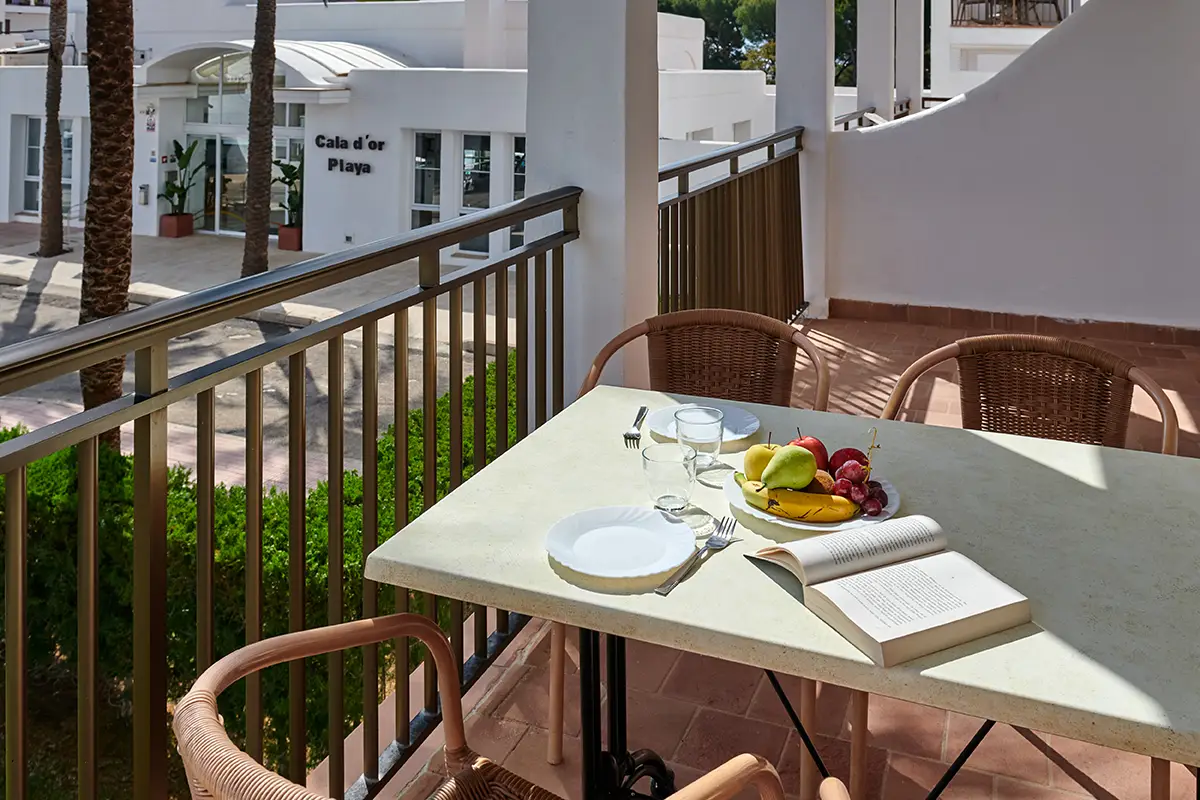 Mesa y sillas en la terraza en Hotel Cala d’Or Playa