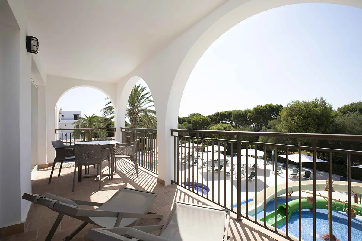 Amplia terraza amueblada con mesa y hamacas en Hotel Cala d’Or Playa